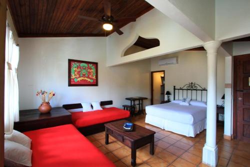 a bedroom with a bed and a living room at Plaza Yat B'alam in Copan Ruinas