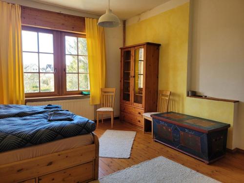 a bedroom with a bed and a cabinet and a table at Haus Schmeile in Magdeburg