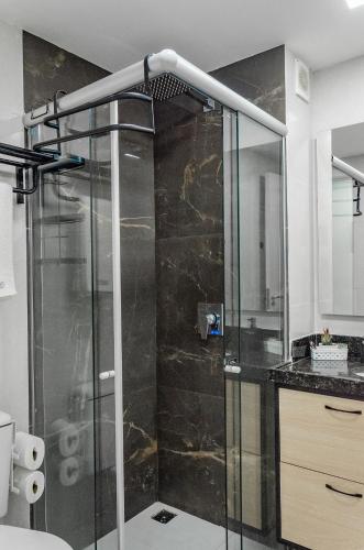 a shower with a glass door in a bathroom at Beachfront Suite with Pool, WIFI and Parking in Ponta Negra in Natal
