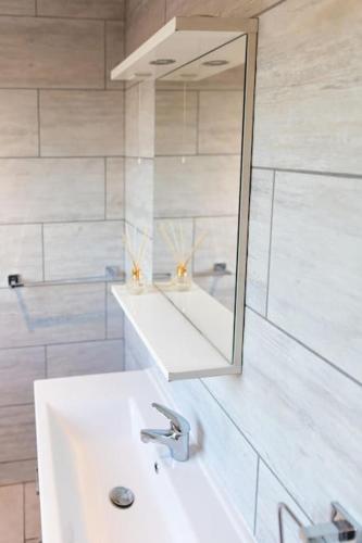 a white bathroom with a sink and a mirror at Modern cottage WiFi Free Parking in Penwortham
