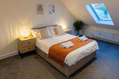 ein Schlafzimmer mit einem Bett mit zwei Handtüchern darauf in der Unterkunft Modern cottage WiFi Free Parking in Penwortham