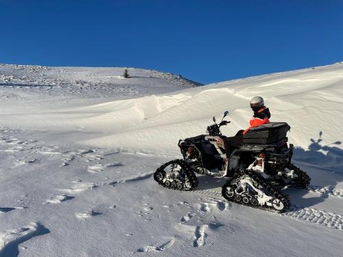 a person riding a quad bike in the snow at Apartman Mila Vlašić in Šišava