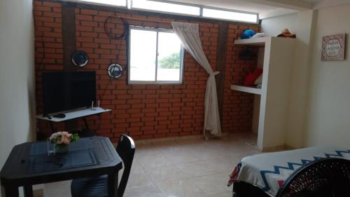 sala de estar con mesa y ventana en Apartaestudio en Tumaco, en Burrero