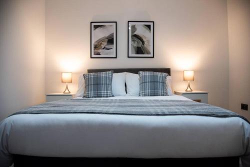 a bedroom with a large bed with three pictures on the wall at Saxon House, sleeps 5, free parking in London