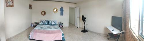 ein Schlafzimmer mit einem Bett und einem Schreibtisch in einem Zimmer in der Unterkunft Apartaestudio en Tumaco in Burrero