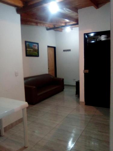 een woonkamer met een bank en een deur bij La posada de memo in Guatapé