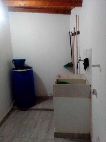 a bathroom with a trash can and a blue trash can at La posada de memo in Guatapé