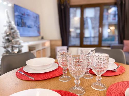 a table with wine glasses and plates and a christmas tree at Apartamento Romántico & Céntrico En Encamp - 4pax l by BonesVacances in Encamp