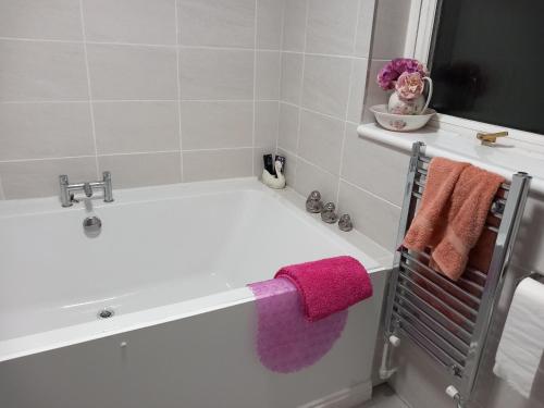 a bathroom with a bath tub with towels on it at Couple's Retreat-West Kilbride in Seamill