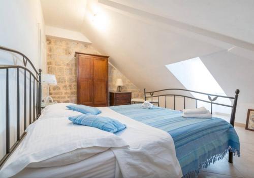 a bedroom with a bed with blue pillows on it at Apartment Saraka in Dubrovnik