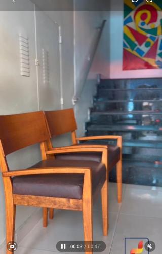 two wooden chairs sitting in front of some stairs at Piaui Apart Hotel in Teresina