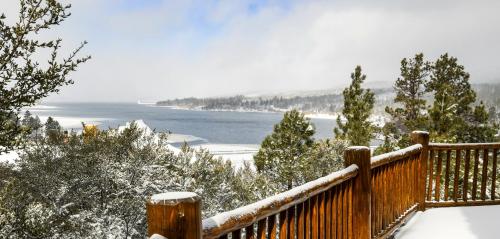 a snow covered deck with a view of a lake at 59 - Lakeview Lodge home in Big Bear Lake