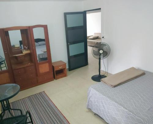 a bedroom with a bed and a desk and a fan at Barrett Accommodation Rooms in Suva