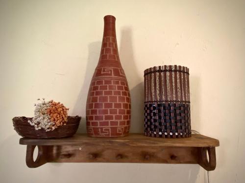 a vase and a basket on a shelf at Tropicália Hostel e Pousada in Itacaré