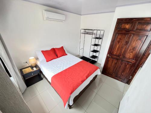 - une chambre avec un lit et une couverture rouge dans l'établissement Casa Gamboa, La Fortuna, à Fortuna