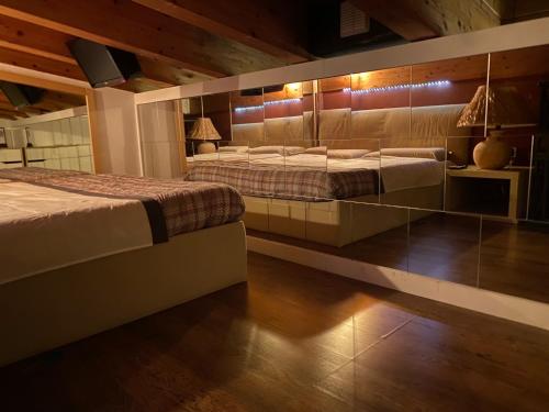 ソンマ・ロンバルドにあるA&A Rooftopのベッド2台(壁に照明付)が備わるベッドルーム1室