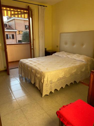 ein Schlafzimmer mit einem Bett und einem großen Fenster in der Unterkunft IL NIDO DI RONDINE in Siena