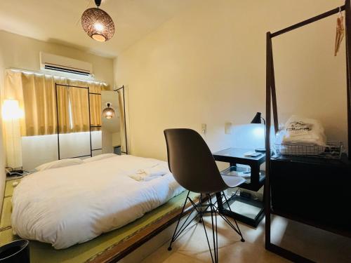 a bedroom with a bed and a desk and a chair at Hotel&Co. Sagami in Tokyo