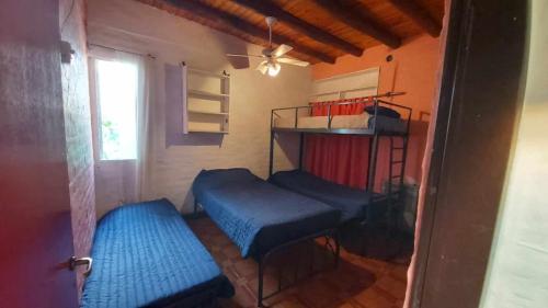 Habitación con 2 camas en una habitación con ventana en Alquilo Casa, 2 Dormitorios y 1 Baño en Maipú