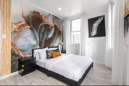 a bedroom with a bed and a painting on the wall at Luxury Living in the Heart of NY! in Yonkers