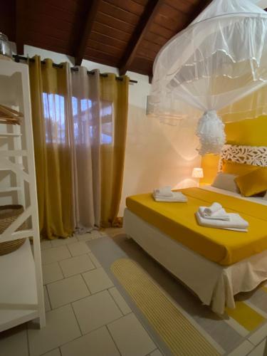 Un dormitorio con una cama amarilla y una escalera en Chez Soul~Etage entier avec vue sur mer, en Sainte-Rose