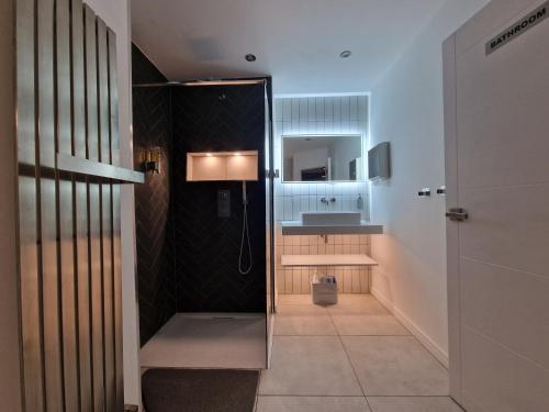 ein Bad mit einer Dusche und einem Waschbecken in der Unterkunft Beautiful Rooms in London in London