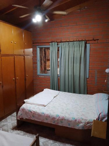 a bedroom with a bed and a brick wall at Casa Paganelli Germano in Aristóbulo del Valle