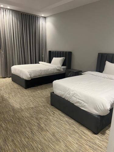 2 Betten in einem Hotelzimmer mit Röcken in der Unterkunft شقق النخبة غرفة نوم وجلسة استديو in As Sayl aş Şaghīr