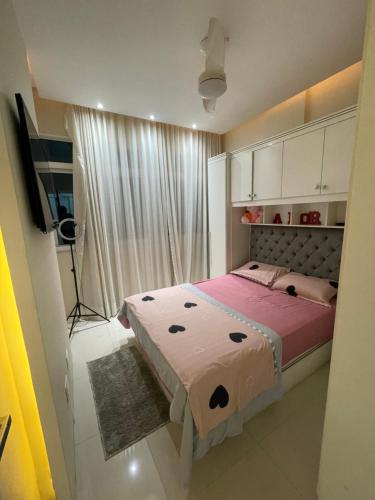a bedroom with a bed with pink sheets and a window at Apartamento Copacabana Luxo in Rio de Janeiro