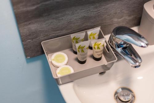 a tray on a sink with toothbrushes and soap at Heart of Maidstone - Premium Double Rooms with FREE Wi-Fi in Maidstone
