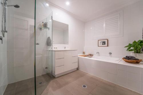 a bathroom with a shower and a tub and a sink at Argentille Boutique Accommodation in Rothbury