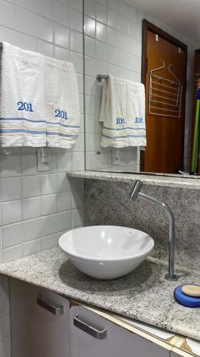 a bathroom with a white sink and towels on a counter at Flat Marupiara suítes com a melhor vista de Muro Alto in Porto De Galinhas