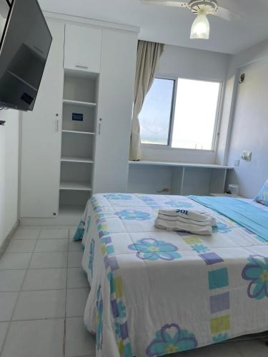 a bedroom with a bed with towels on it at Flat Marupiara suítes com a melhor vista de Muro Alto in Porto De Galinhas