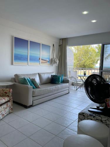 a living room with a couch and a view of the ocean at Flat Marupiara suítes com a melhor vista de Muro Alto in Porto De Galinhas
