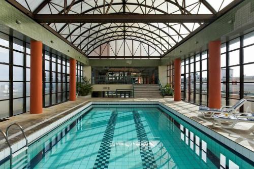 una gran piscina con techo de cristal en Flat reformado no Piazza Navona en Porto Alegre