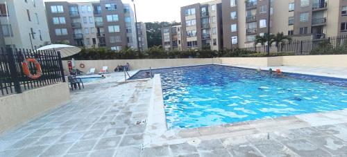 a large swimming pool in a building with tall buildings at La Katiritaa in Villavicencio