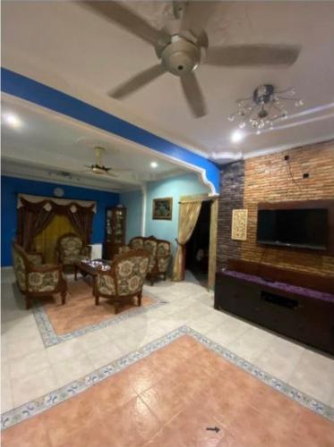 a living room with a fireplace and a tv at de Mawaddah Homestay in Kluang