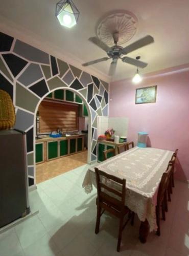 a dining room with a table and a ceiling fan at de Mawaddah Homestay in Kluang