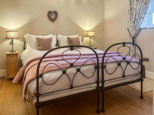 a bedroom with a bed with a metal frame at Mill Cottage in Ravensworth