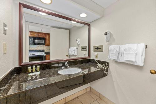 Un baño con lavabo y un espejo grande. en Landmark Resort, 1BR Oceanfront, en Myrtle Beach