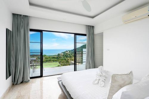 ein Schlafzimmer mit einem weißen Bett und einem großen Fenster in der Unterkunft VILLA DOVE Hillside Modern Infinity Sea View Pool in Strand Chaweng Noi