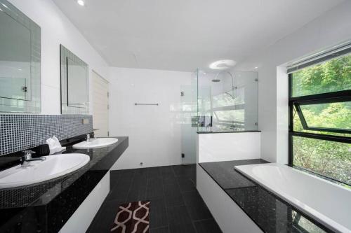 ein weißes Bad mit 2 Waschbecken und einem Fenster in der Unterkunft VILLA DOVE Hillside Modern Infinity Sea View Pool in Strand Chaweng Noi