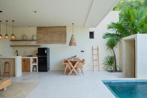 a kitchen and dining room with a table and a swimming pool at Olea Villas Resort in Kuta Lombok