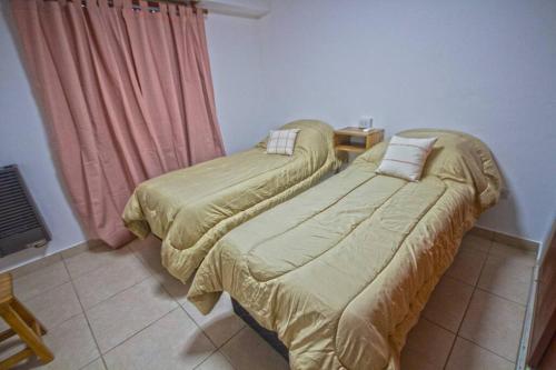 two beds sitting next to each other in a room at Cómodo y Bien Ubicado! in Bahía Blanca