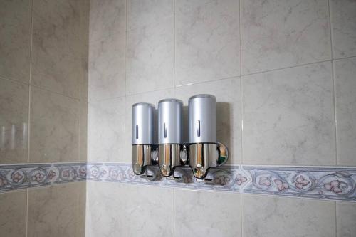 una fila di tazze d'argento su una mensola nella doccia di Cómodo y Bien Ubicado! a Bahía Blanca