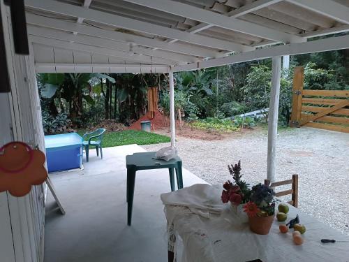 una veranda riparata con tavolo e sedie di Refúgio Florianópolis a São José