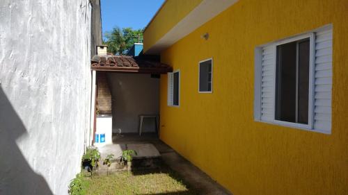 un edificio amarillo con una ventana en el lateral en Recanto Mar Rico en Boracéia