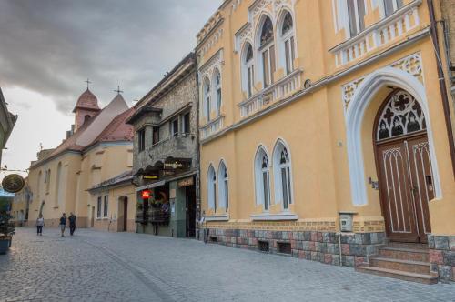 a street in a town with a building with a clock tower at Aki Apartment in Braşov