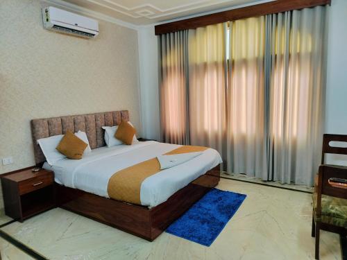 a bedroom with a bed and a large window at Hotel Soft Petal Residency - Delhi Airport in New Delhi