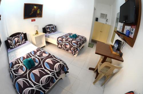 Habitación pequeña con 2 camas y TV. en Isla Water Sports and Resorts Inc, en Batangas